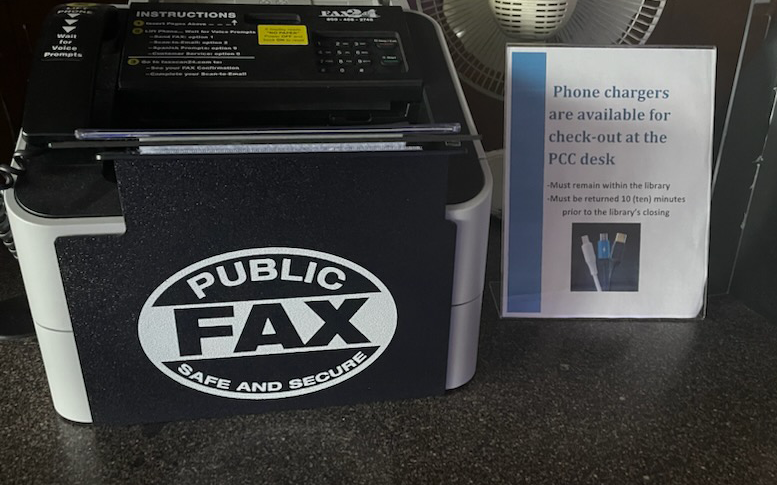 Fax machine and flyer noting phone chargers are available