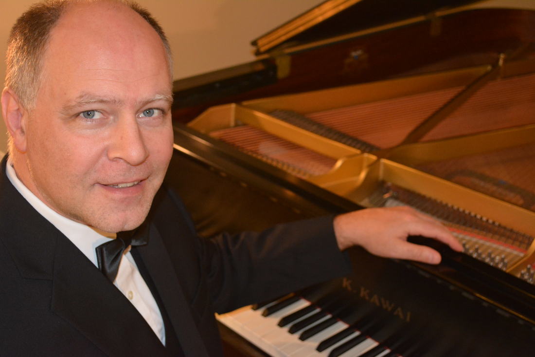 This picture is of pianist/vocalist Peter Bergin sitting next to a piano.