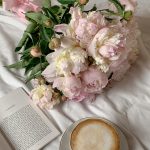 light pink, dried roses next to a book and coffee