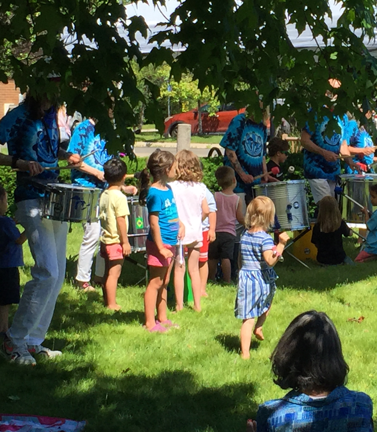 Samba drum troupe performing with children on Main Library front lawn