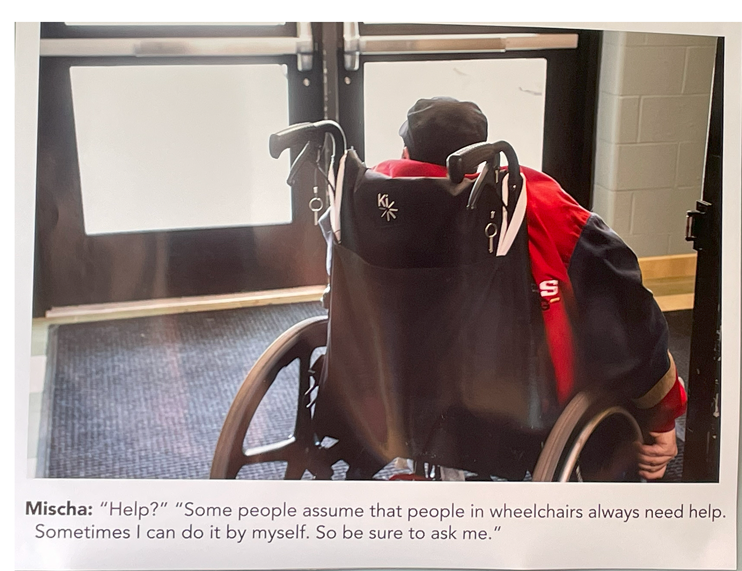 Photo of a person in a wheelchair, from the back, looking out the window