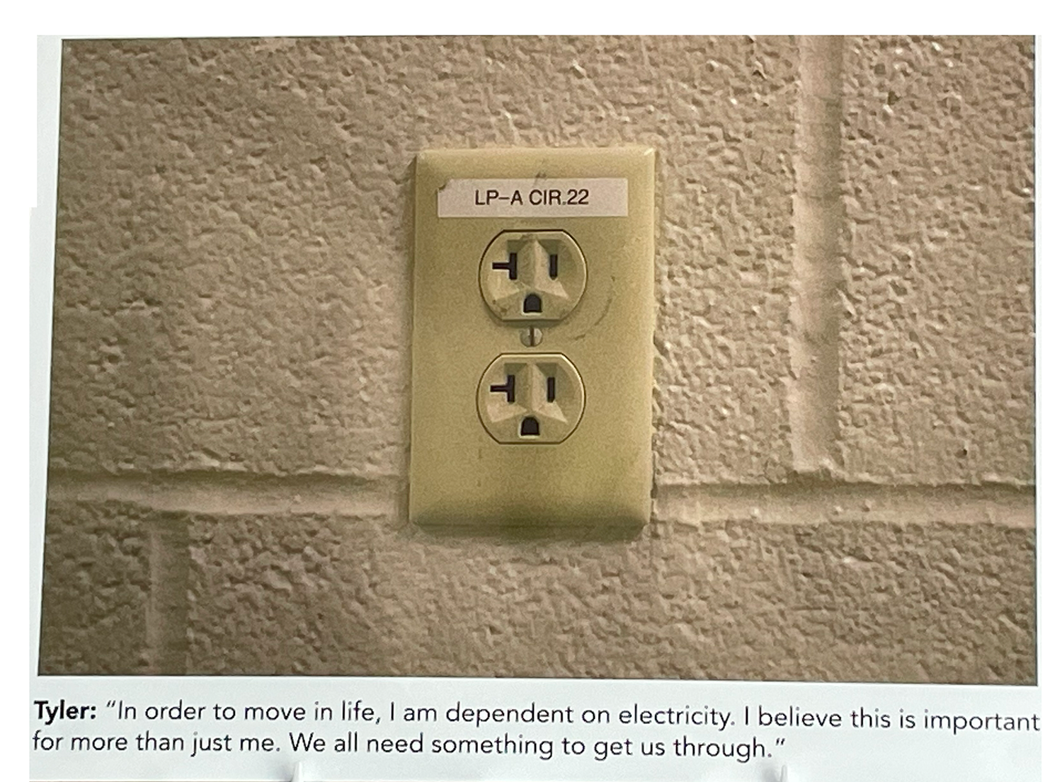 Cream electrical outlet in a cream brick wall