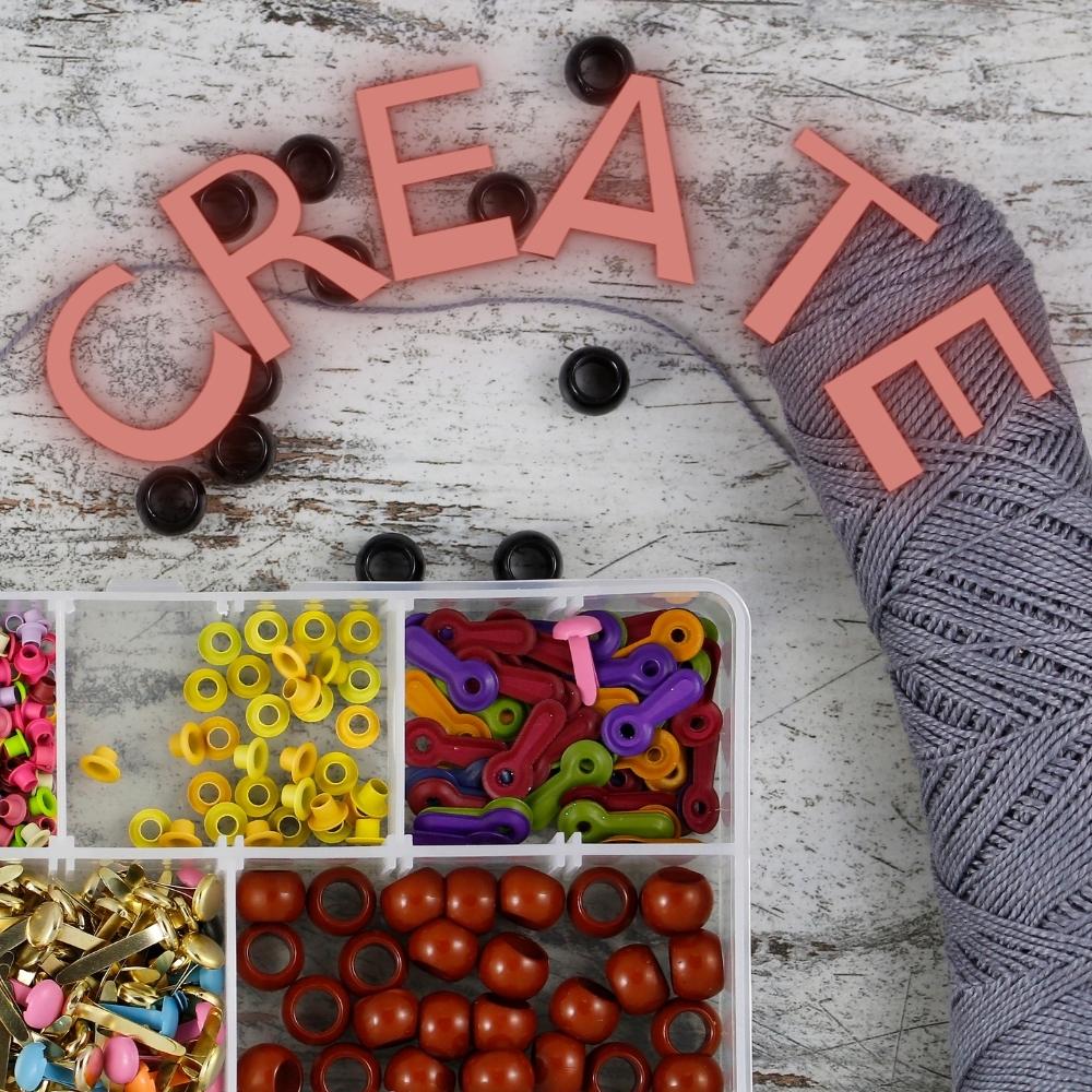 The word create with beads and yarn. 