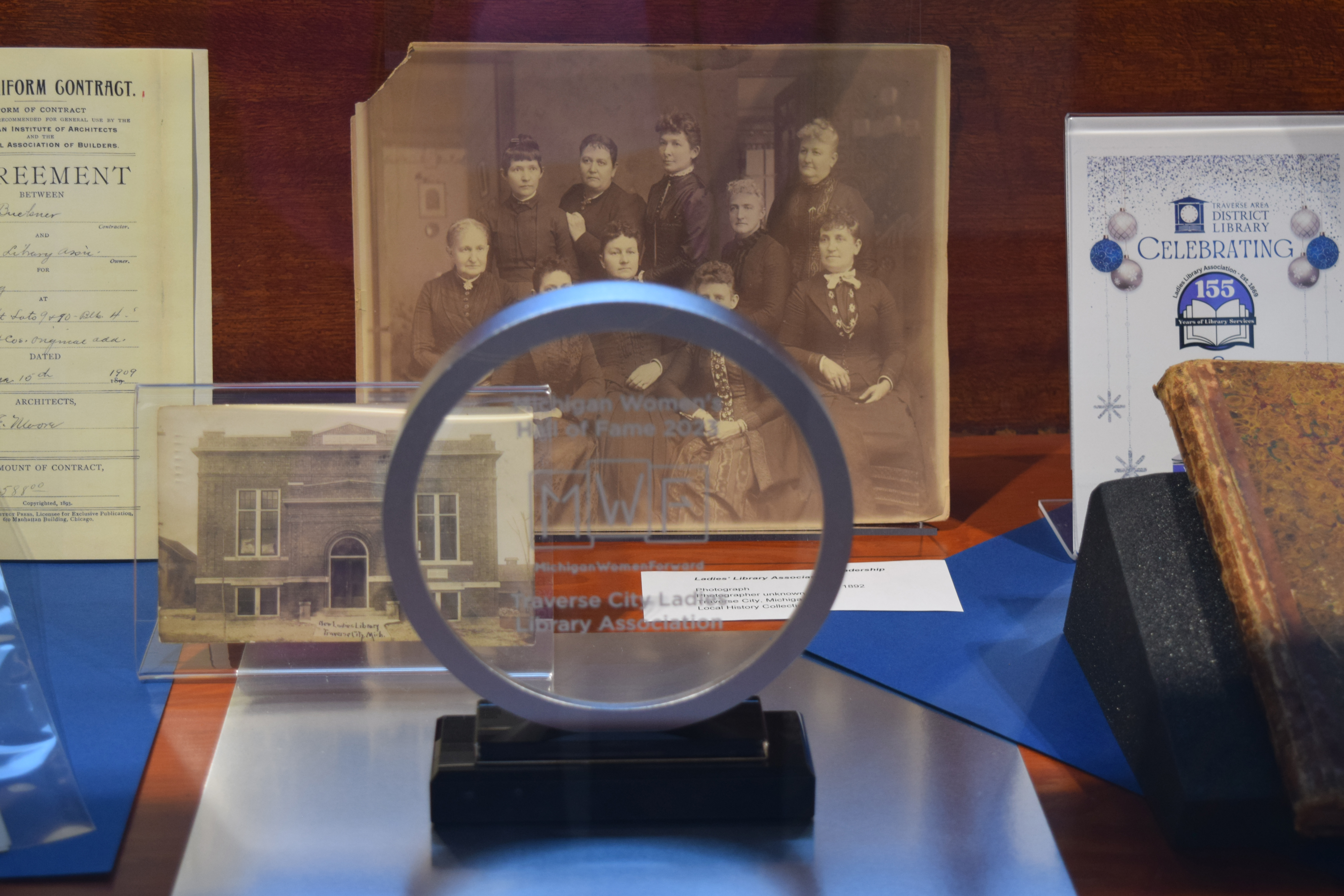 Circular award for the Hall of Fame, with portrait of the ladies behind.