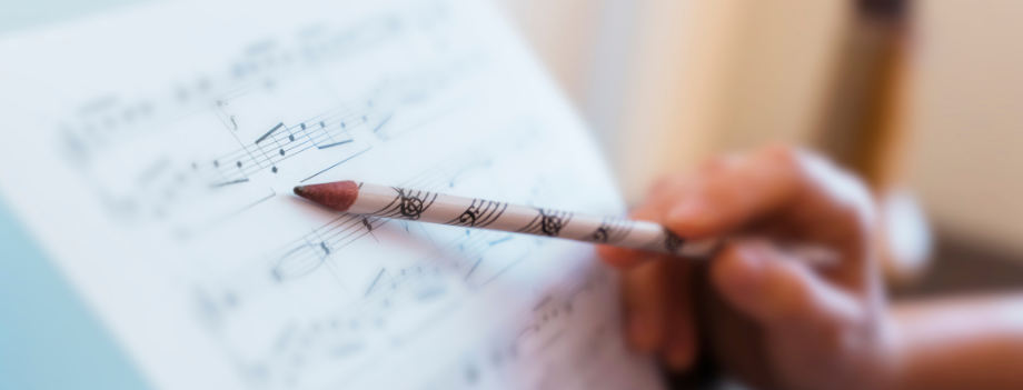 Person following a sheet of music with a pencil