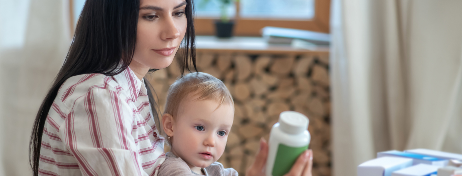 Woman holding a baby and reading a bottle