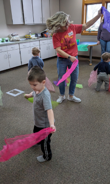 Beth and young patron during movement and dance at Wigglers Storytime.