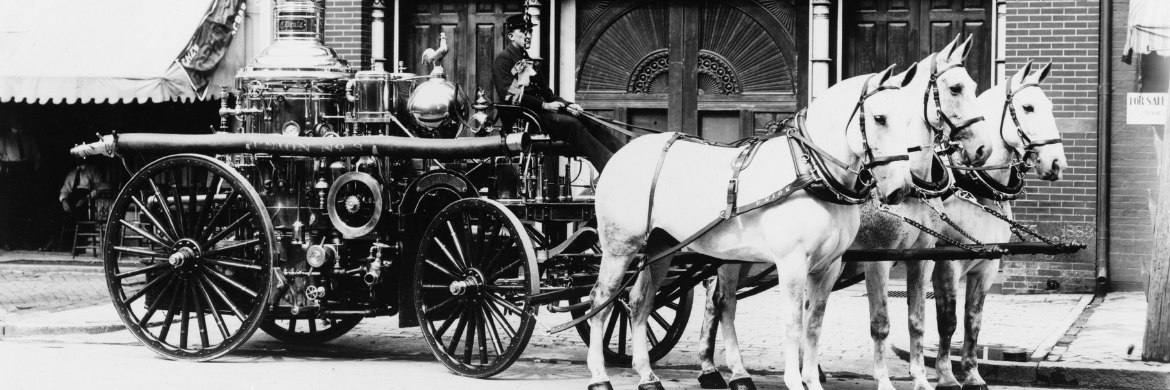 horse drawn fire wagon in black and white