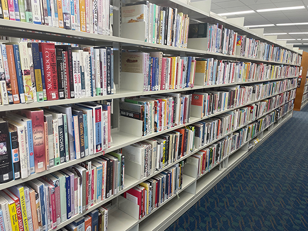 long shelving unit of cookbooks
