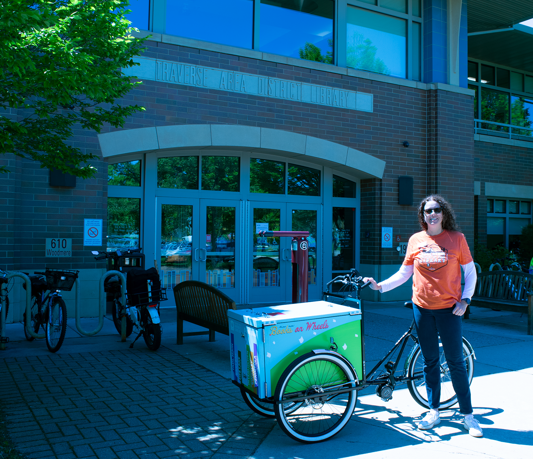 Library Director Michele P. Howard with TADL's new ebike in front of the library