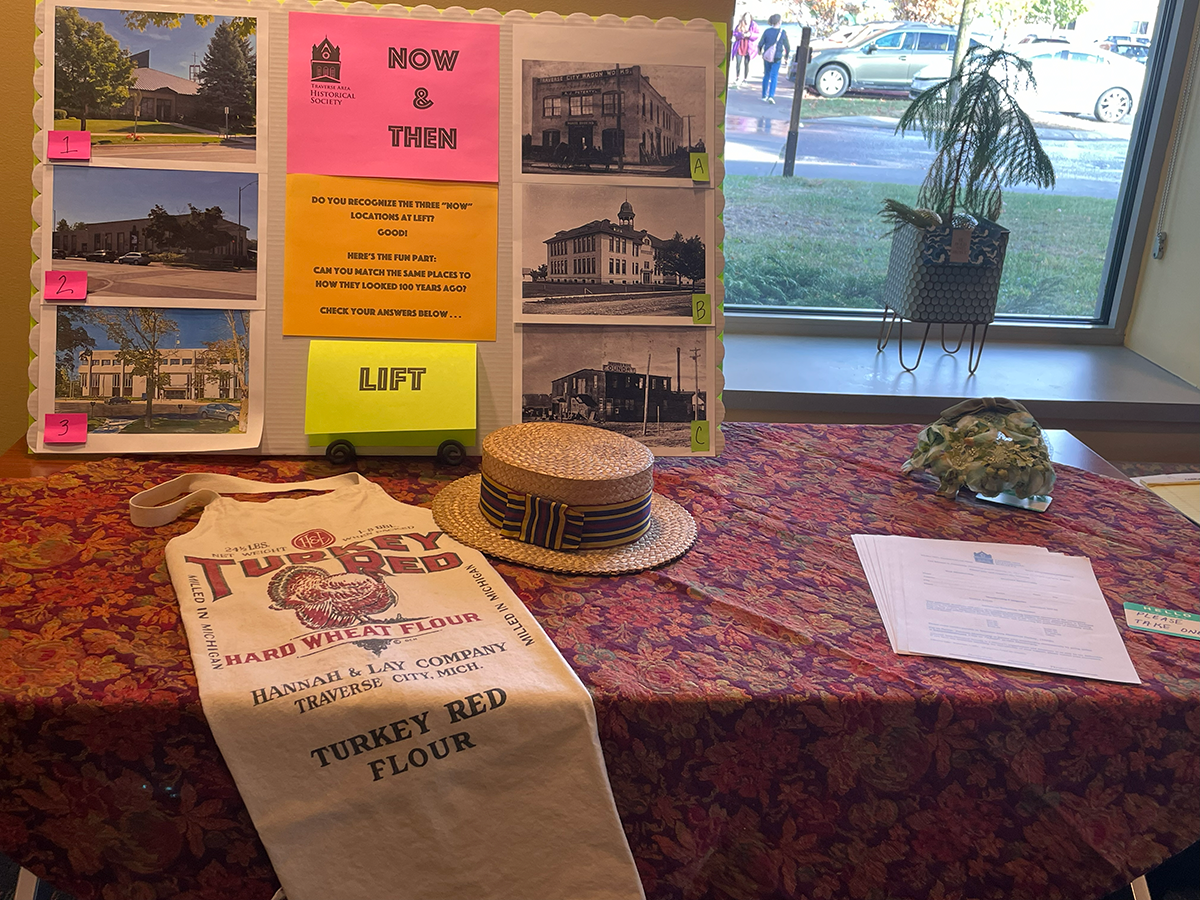 table with historical photos and a straw hat