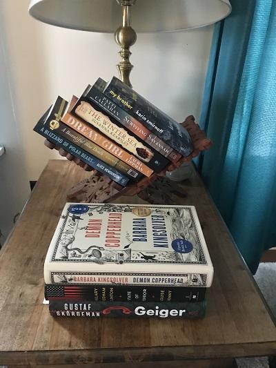 This is a picture of a stack of books on a side table.