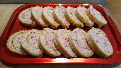 two rows of sliced cranberry orange cake roll on a tray