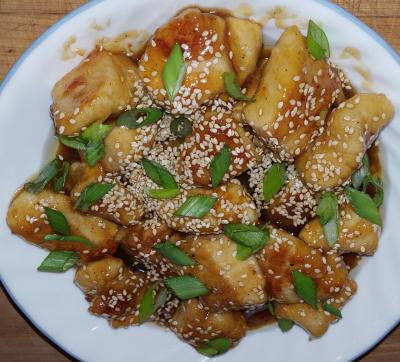 white plate with honey sesame chicken on it