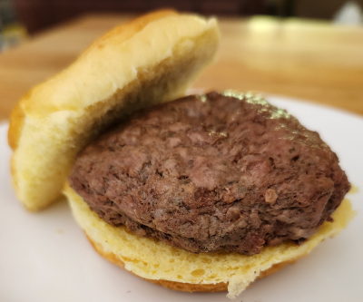 umami burger with bun on white plate