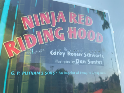 Book cover with title and info added via clear braille tape - book is Ninja Red Riding Hood