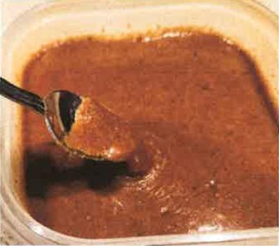Plastic bowl with spoon in enchilada sauce