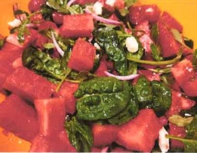 yellow dish filled with watermelon salad with feta