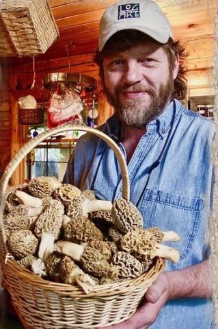 Picture of speaker Tony Williams holding a basket of morel mushrooms.