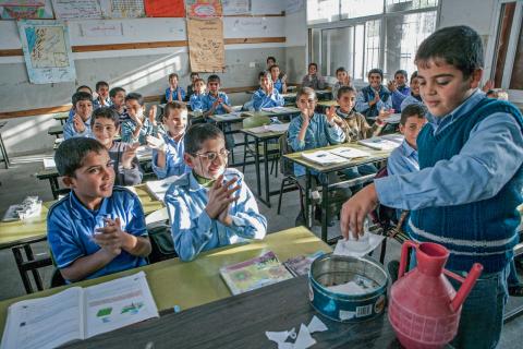 A 4th grade science class at the Osama El Naggar School in the Gaza city, Khan Yunus, November, 2005.  A student successfully performs an experiment and is cheered by his classmates. 