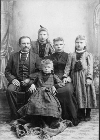 Image of a family consisting of husband, wife, and three children.