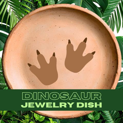 Image of a clay jewelry dish with a pair of dinosaur footprints in its center. Tropical palm fronds are in the background, and a green bar at the bottom of the page has text that reads: Dinosaur Jewelry Dish.