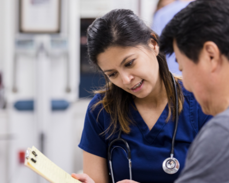 man talking with a nurse about a form in a medical room