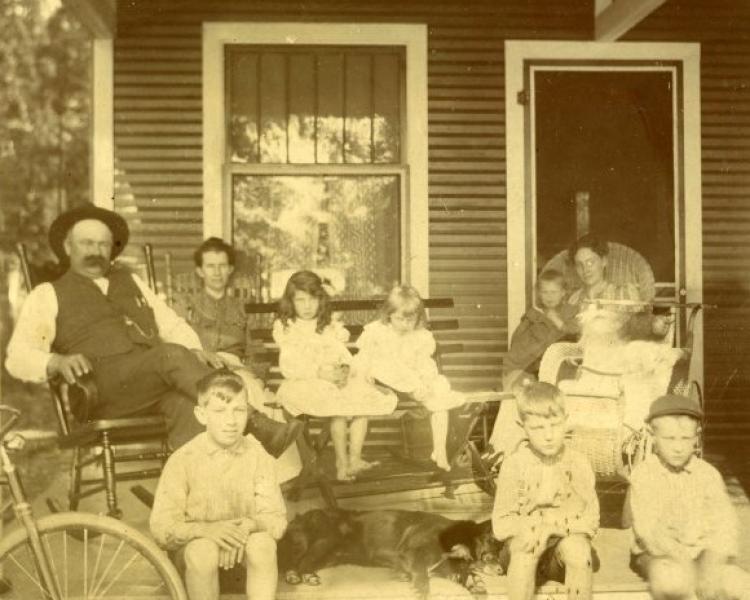 Black and white photo of a family on a porch