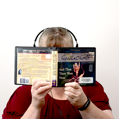 Headshot of Anita Chouinard with audiobook and headphones
